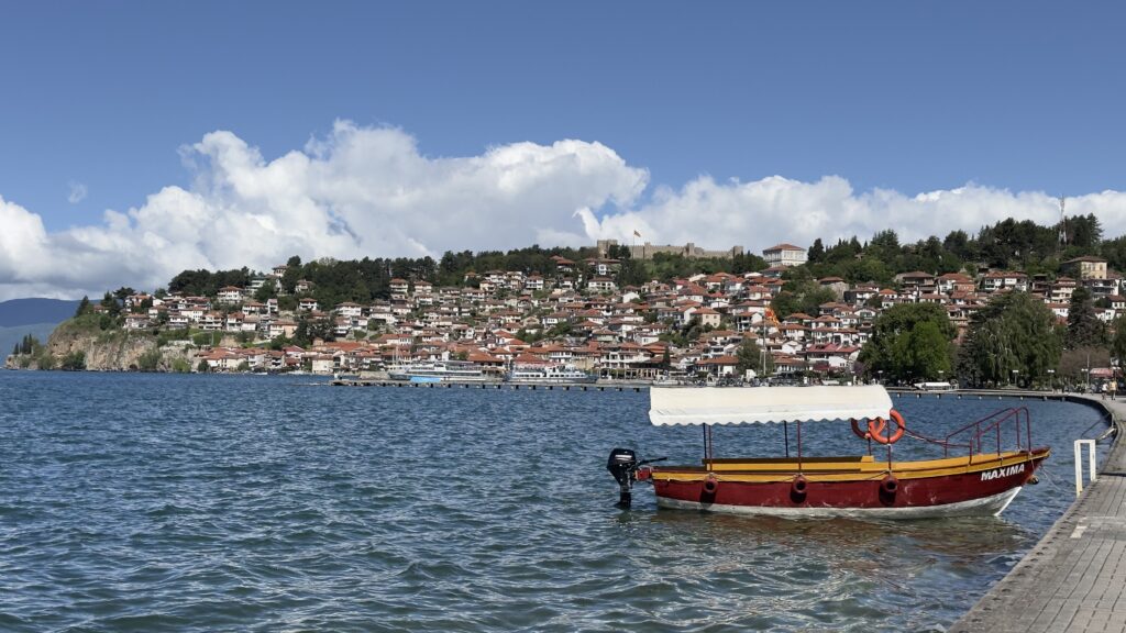Blick von der Promenade in Ohrid auf die Altstadt mit Wasser und Boot am Steg