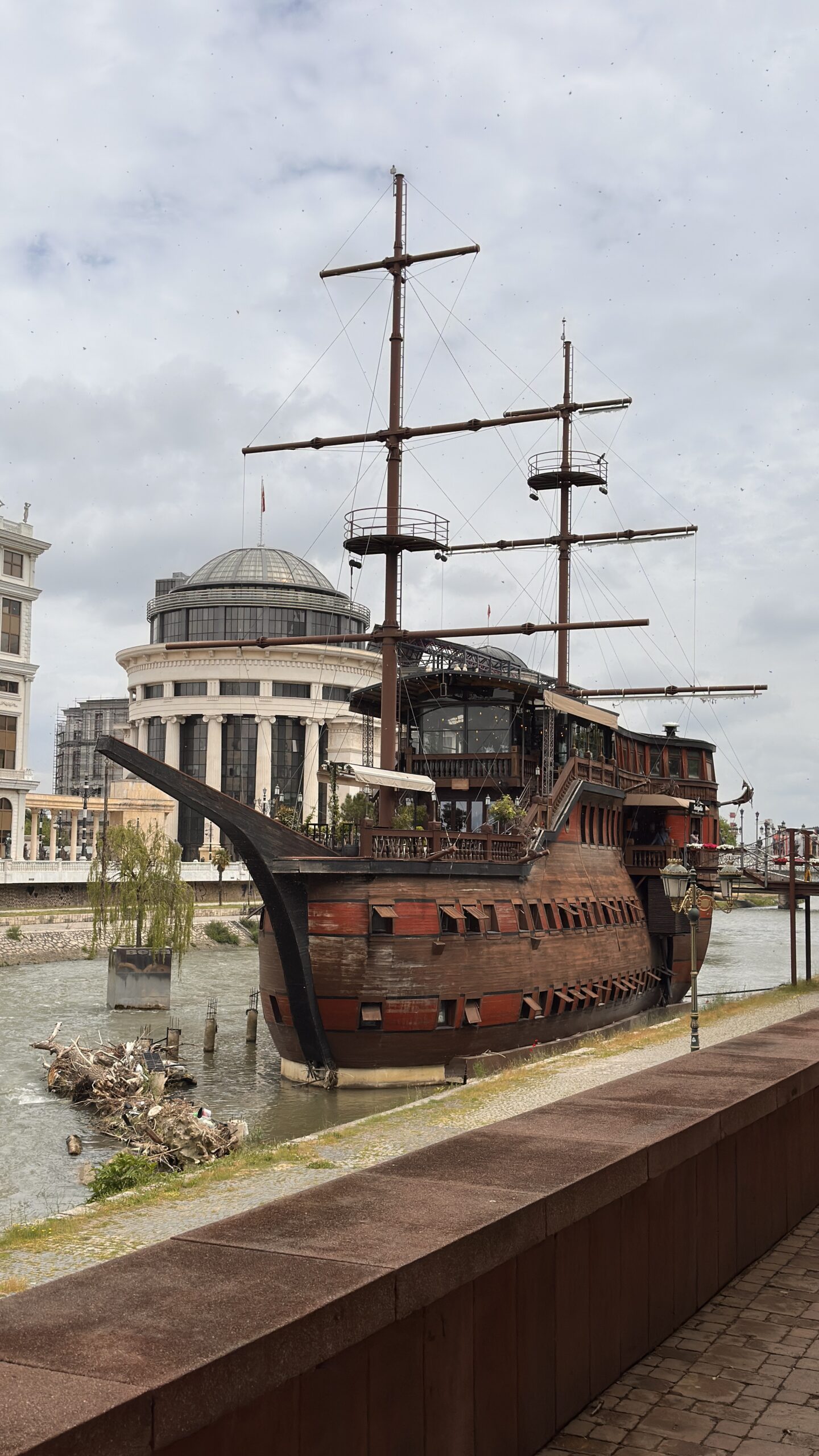 Schiff auf Fluss mit historischen Gebäuden im Hintergrund in Skopje