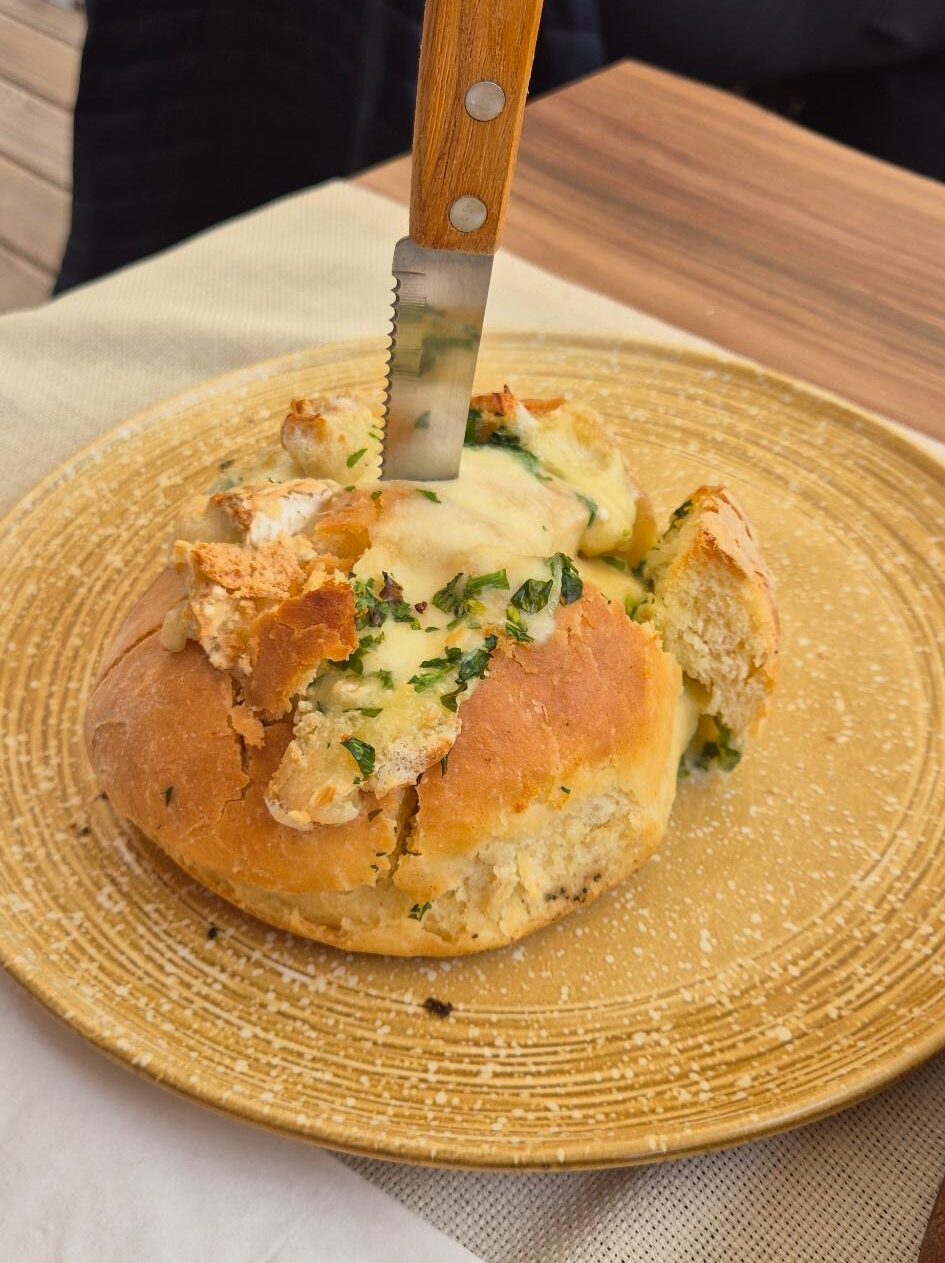Hausbrot gefüllt mit Camembert auf einem Teller angerichtet im Restaurant Dedo Cane in Skopje