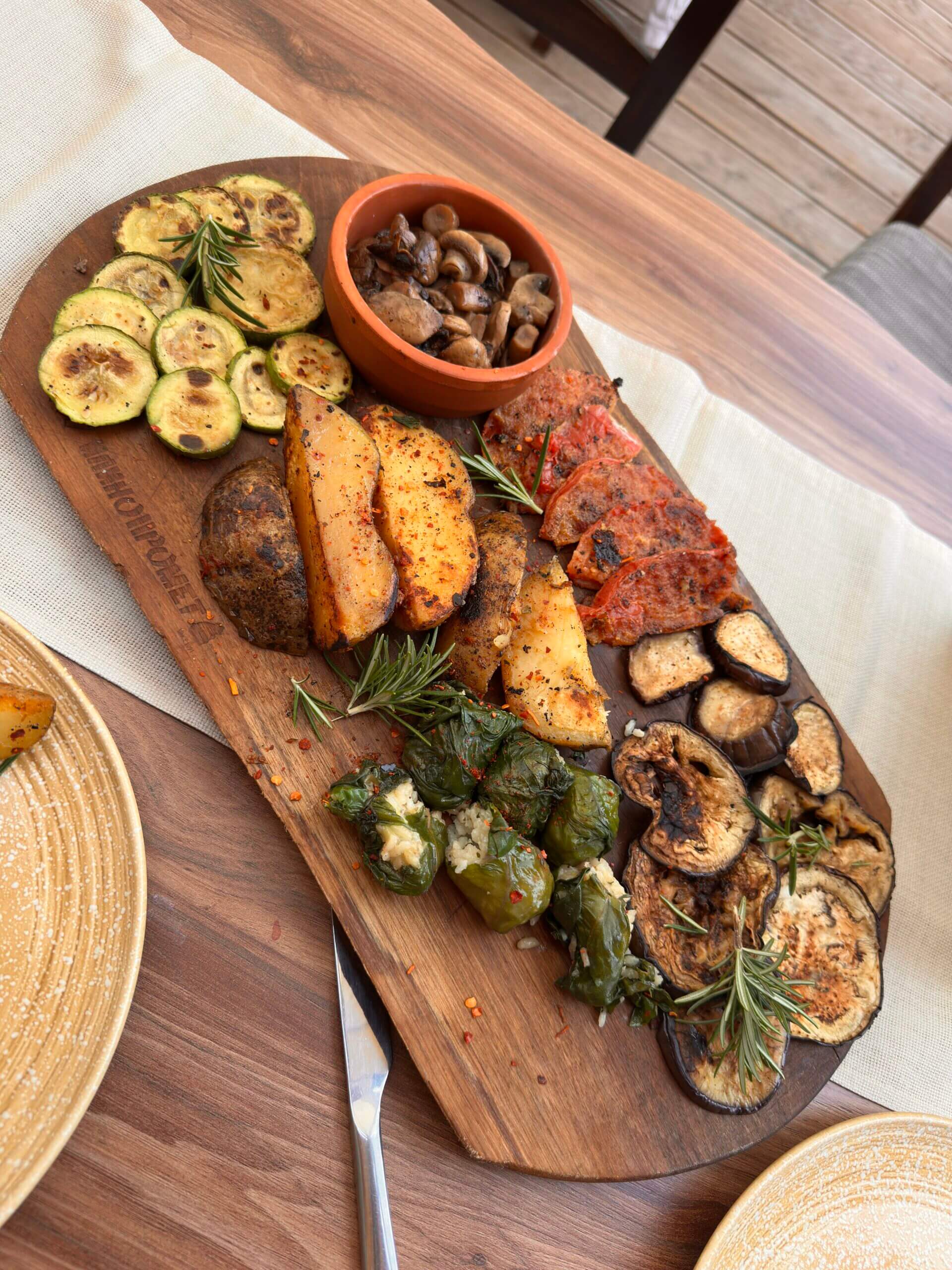 Vorspeisenplatte mit Kartoffeln, Gemüse und Sarma auf einem Holzbrett im Restaurant Dedo Cane in Skopje