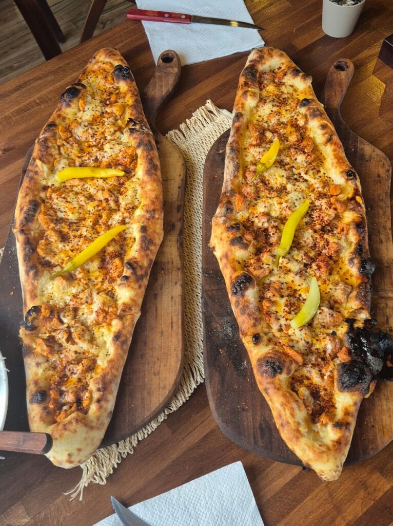 Zwei Pastrmajlija auf Holzbrettern serviert