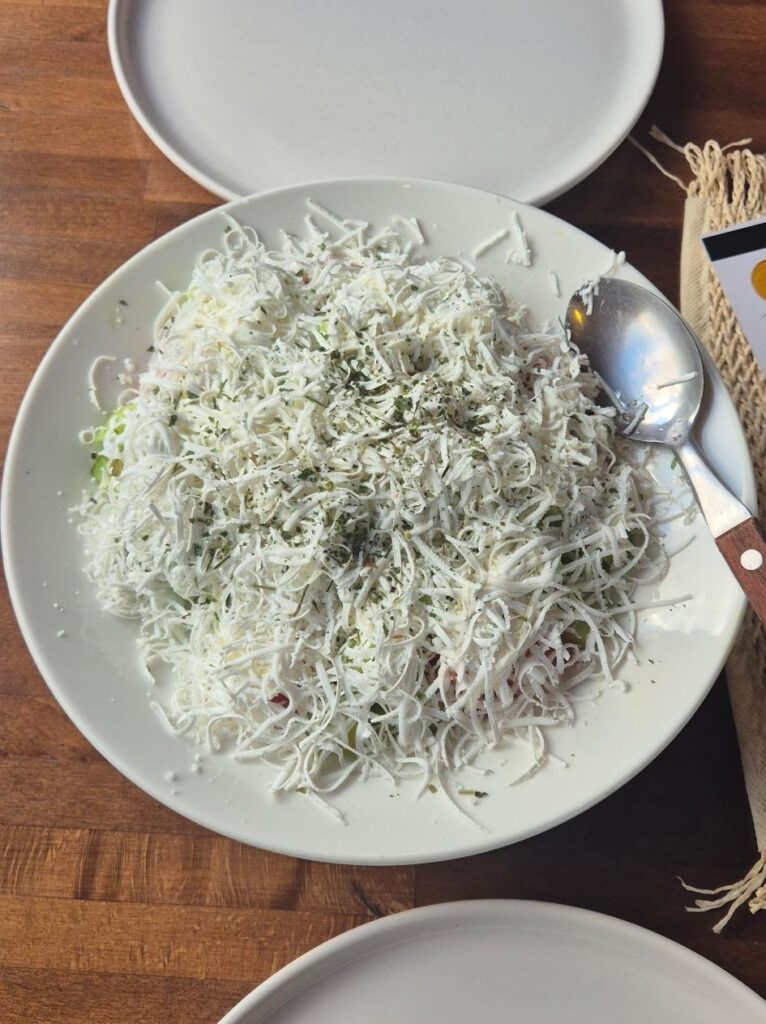 Skopska Salat mit geriebenem Schafskäse auf einem Teller serviert