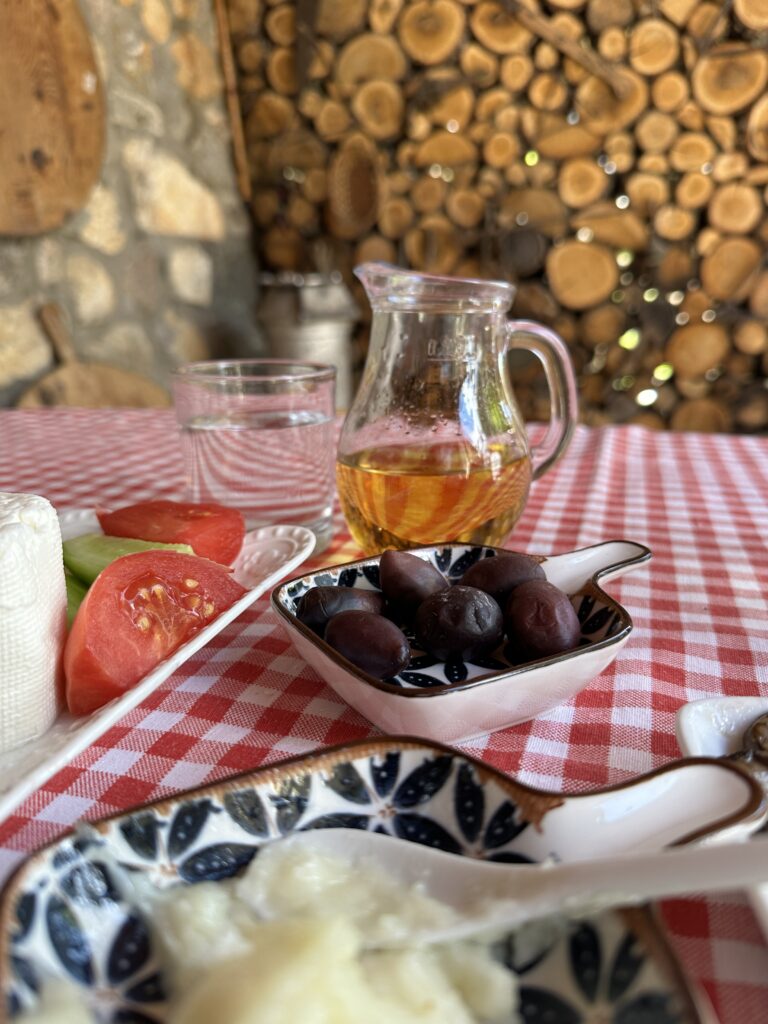 Oliven, Schafskäse, Tomaten und Rakija auf einem Tisch angerichtet