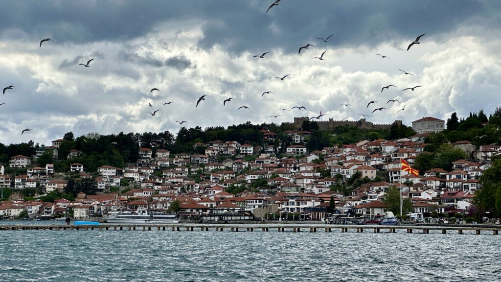 Blick auf Altstadt von Ohrid am See mit dunklen Wolken und Vögeln vor dunklen Wolken
