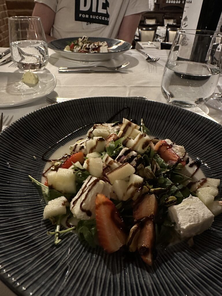 Angerichteter Gang eines Menüs mit Salat, Feta, Erdbeeren und Balsamico-Soße im Restaurant des Tikves-Weingut