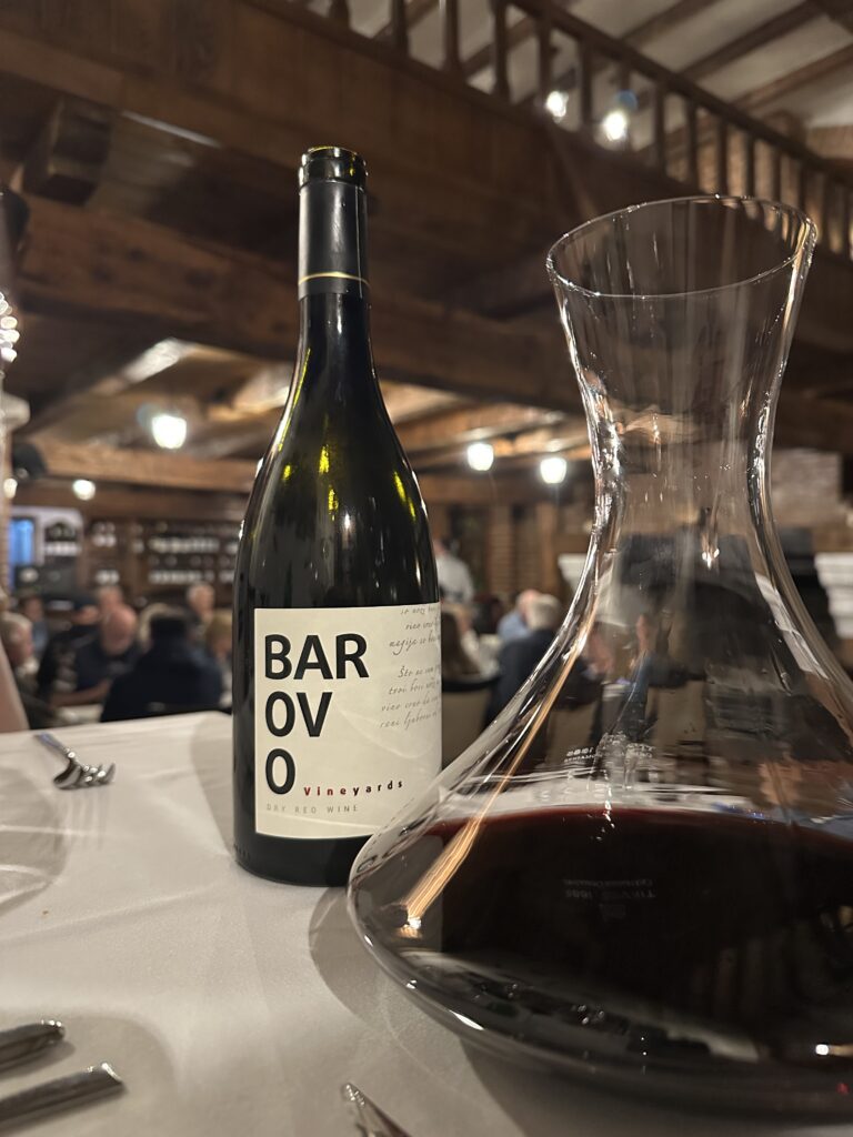 Weinflasche mit halbgefülltem Dekanter auf einem Tisch im Restaurant des Tikves-Weingut