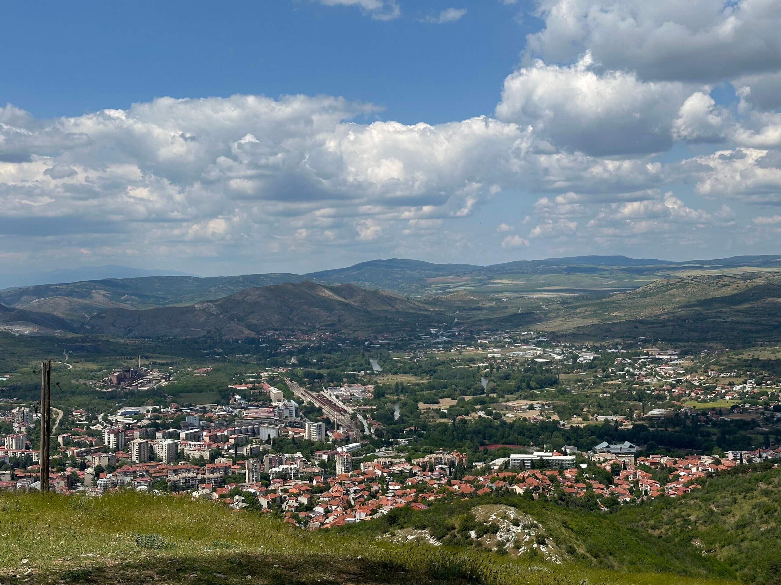 Berge im Hintergrund mit blauem Himmel und einigen Wolken mit Blick auf die Stadt Veles im Tal