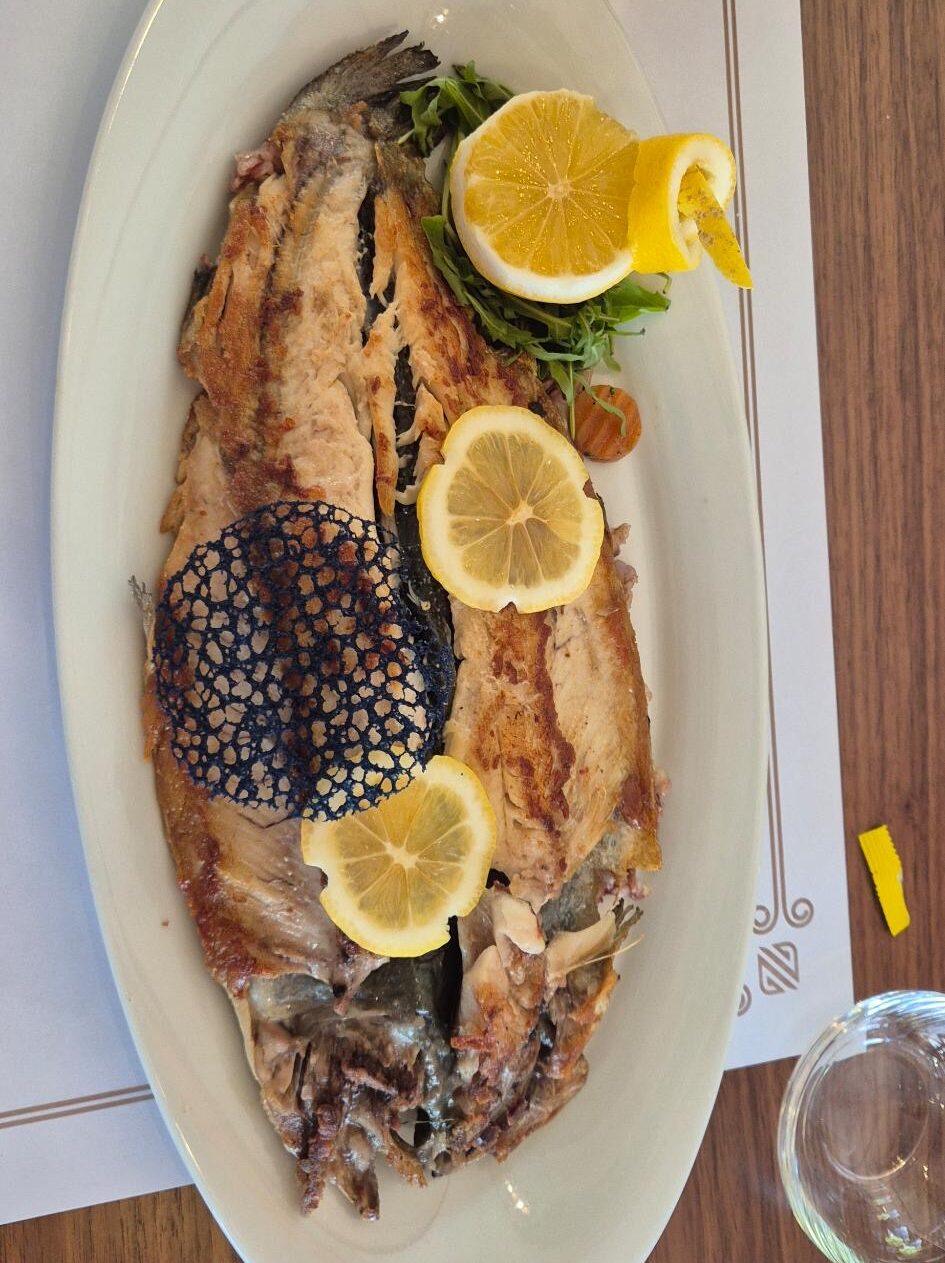 Flussforelle mit Zitronenscheiben auf einem Teller im Restaurant ZEN Gastronomy Concept