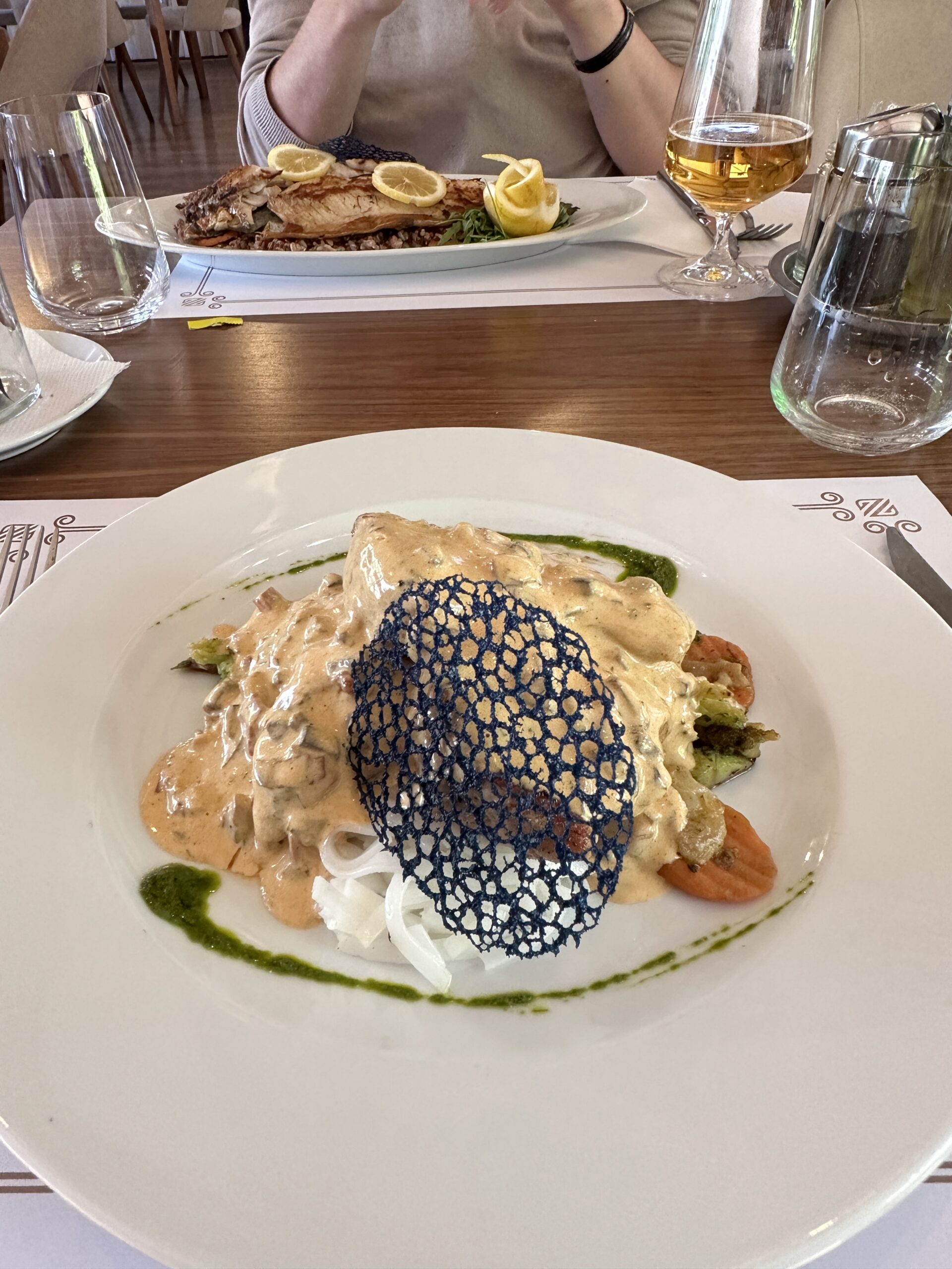 Schweinefilet angerichtet auf einem Teller mit Pilzsoße, Gemüse und Reisnudeln im Restaurant ZEN Gastronomy Concept